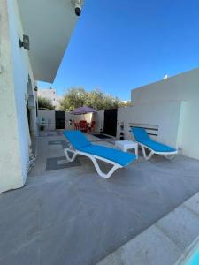 a patio with two blue chairs and a table at Dar Souleyman in Midoun