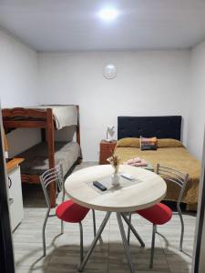 a room with a table and two chairs and a bed at Refugio de Paso Ezeiza in Ezeiza