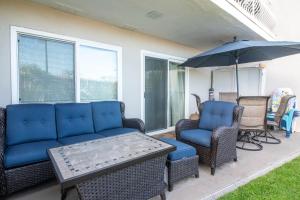 a patio with a couch and chairs and an umbrella at Carpinteria Shores CS 103 in Carpinteria