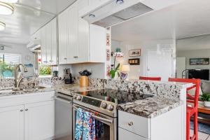 a kitchen with white cabinets and granite counter tops at Carpinteria Shores CS 103 in Carpinteria