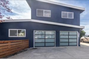 a blue house with sliding garage doors at Bella Surf in Avila Beach
