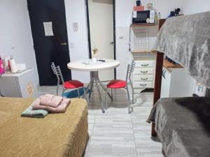 a small room with a table and a table and chairs at Refugio de Paso Ezeiza in Ezeiza +2 photos