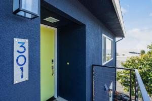 a blue house with a yellow door and a balcony at Bella Surf in Avila Beach