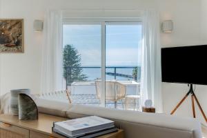 a living room with a couch and a large window at Bella Surf in Avila Beach