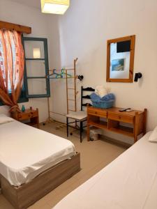 a bedroom with two beds and a desk and a mirror at PANSION KONSTANTINOS in Skiathos