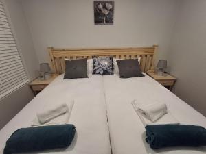 a large white bed in a bedroom with two chairs at SafeHaven 45 in George +17 photos