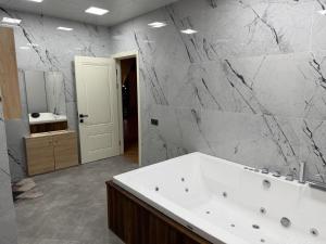 ein Badezimmer mit weißer Badewanne und Marmorwand in der Unterkunft Rıver Forest Hotel in İsmayıllı + 26 Fotos