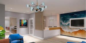 a living room with a tv and a blue chair at Days Inn by Wyndham Encinitas Moonlight Beach in Encinitas