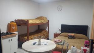 a small room with a table and a bed and a table and a tablektop at Refugio de Paso Ezeiza in Ezeiza