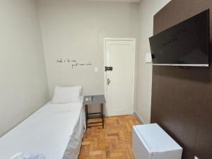 ein kleines Zimmer mit einem Bett und einem Tisch in der Unterkunft Hotel Divinopolis Center - Alguel de Temporada in Divinópolis