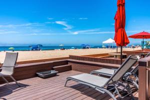 a deck with chairs and umbrellas on the beach at Carpinteria Shores CS 110 in Carpinteria