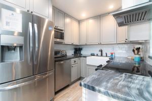 a kitchen with white cabinets and a stainless steel refrigerator at Carpinteria Shores CS 110 in Carpinteria +16 photos