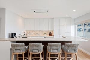 a kitchen with white cabinets and a counter with chairs at Carpinteria Shores CS 107 in Carpinteria