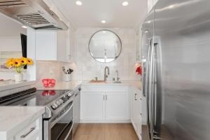 a kitchen with white cabinets and a stainless steel refrigerator at Carpinteria Shores CS 209 in Carpinteria