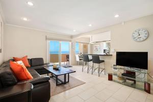 a living room with a couch and a clock on the wall at Carpinteria Shores CS 212 in Carpinteria
