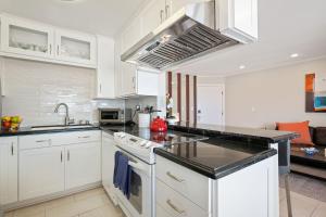 a kitchen with white cabinets and a stove top oven at Carpinteria Shores CS 212 in Carpinteria