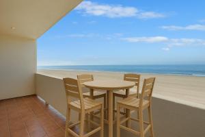 a table and chairs in a balcony with a view of the beach at Carpinteria Shores CS 210 in Carpinteria