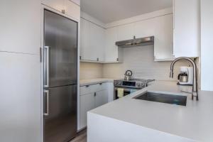 a kitchen with white cabinets and a stainless steel refrigerator at Carpinteria Shores CS 312 in Carpinteria +12 photos
