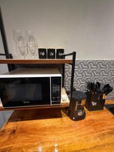 a microwave sitting on top of a wooden table at Chalé Exclusive El Paso in Mairiporã