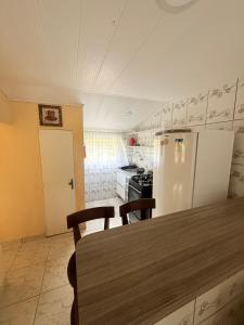 a kitchen with a refrigerator and a table with chairs at Casa baixinha in Ubajara