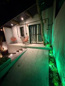 a house with two chairs and a swimming pool at night at Chalé Exclusive El Paso in Mairiporã