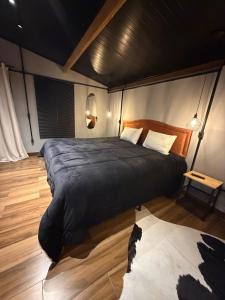 a bedroom with a large bed and a wooden floor at Chalé Exclusive El Paso in Mairiporã +25 photos
