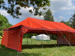 a red tent in the grass in a field at Jurtowisko in Wilcza Wólka +10 photos