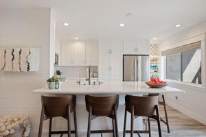 a kitchen with a large white island with bar stools at Carpinteria Shores CS 109 in Carpinteria +18 photos
