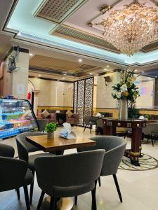 a lobby with a table and chairs and a chandelier at Al Muhajir Serviced Apartments Quraish Branch in Jeddah