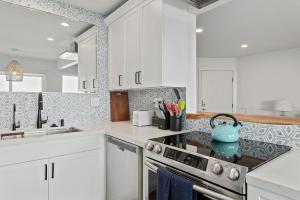 a kitchen with white cabinets and a blue tea kettle on the stove at Carpinteria Shores CS 206 in Carpinteria