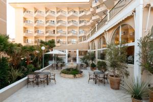 eine Außenterrasse mit Tischen und Stühlen in einem Gebäude in der Unterkunft Hotel Guardamar in Guardamar del Segura