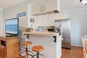 a kitchen with a counter and two stools at Carpinteria Shores CS 302 in Carpinteria