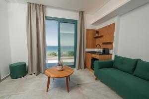 a living room with a green couch and a table at Villa Gonates in Limenaria