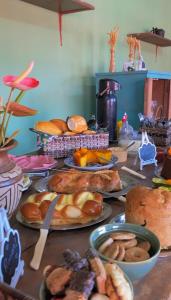a table topped with plates of bread and pastries at Pousada Pico do Papagaio in Aiuruoca