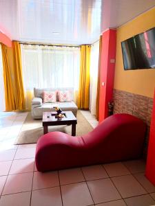 a living room with a red couch and a tv at Kenai Mountain View in Concepción