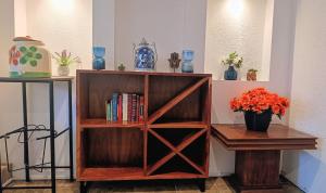 a book shelf with books and a vase of flowers at Lake side Luxury Duplex ! in Jurica