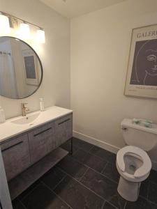 a bathroom with a toilet and a sink and a mirror at The Hotel on Pownal in Charlottetown
