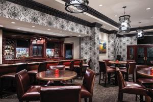 a bar with tables and chairs in a room at Horseshoe Bossier City Hotel & Casino - A Caesars Rewards Destination in Bossier City
