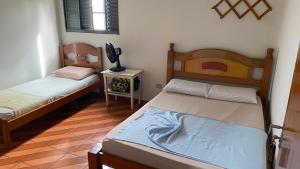 a room with two beds and a television in it at Hotel Gênio in Pouso Alegre