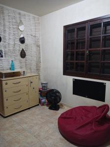 a living room with a dresser and a tv at Suíte em casa particular in Lagoa Santa