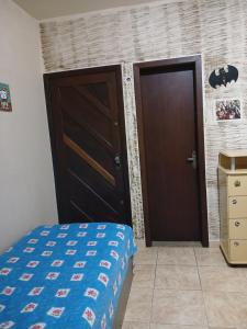 a bedroom with a bed and a door and a dresser at Suíte em casa particular in Lagoa Santa