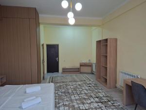 a room with a bed and a desk and a cabinet at Comfort Hotel in Almaty