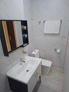 a white bathroom with a sink and a toilet at Comfort Hotel in Almaty