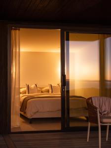 a bedroom with a bed and a sliding glass door at The Hide Kapiti Accommodation in Paraparaumu