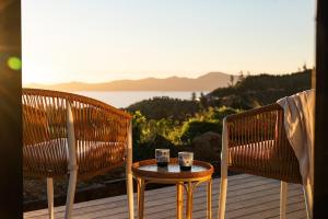 two chairs and a table with two candles on a deck at The Hide Kapiti Accommodation in Paraparaumu +12 photos
