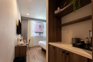 a room with a bed and a room with a kitchen at Kins Hotel in Los Angeles