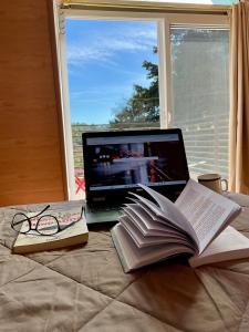 a laptop computer sitting on top of a bed with books at Cabaña, fogata, terraza in Santiago Sacatepéquez