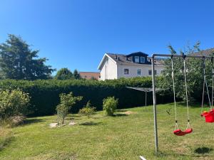 a swing in a yard with a house in the background at Sommarboende i centrala Varberg in Varberg