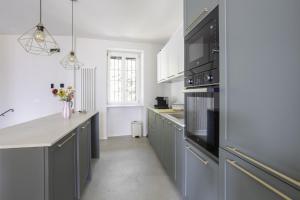 a kitchen with gray cabinets and a counter top at Antica Villa Branca by Lago Maggiore Rentals in Cannobio