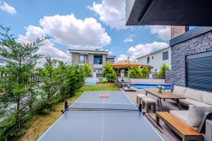 a backyard with a ping pong table and benches at Luxury Forest Villas with Private Pool in Antalya